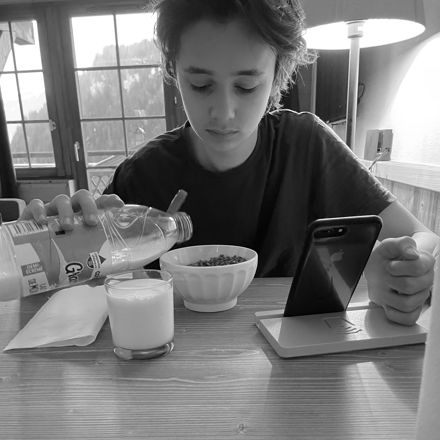 Founder of Scroller Coaster having breakfast, pouring milk on cereal in Chatel, French alps